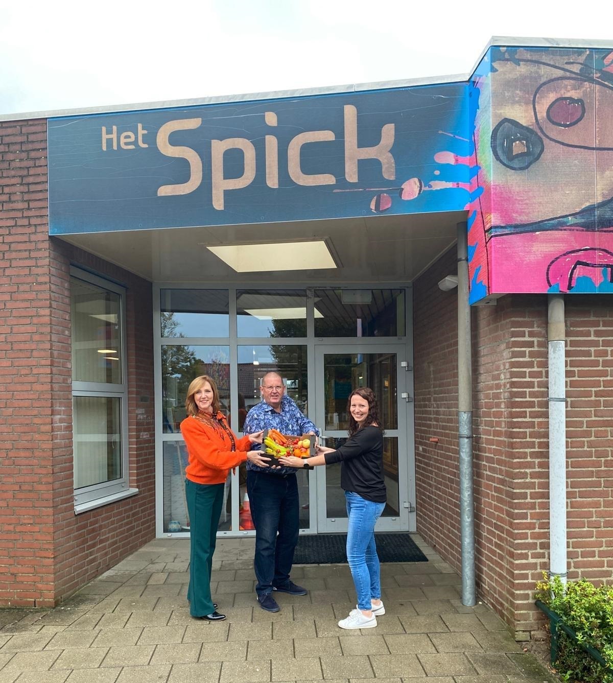 Wethouder Angely Waajen-Crins en Ton Baetsen van Rendiz overhandigen het eerste kistje schoolfruit aan basisschool 't Spick